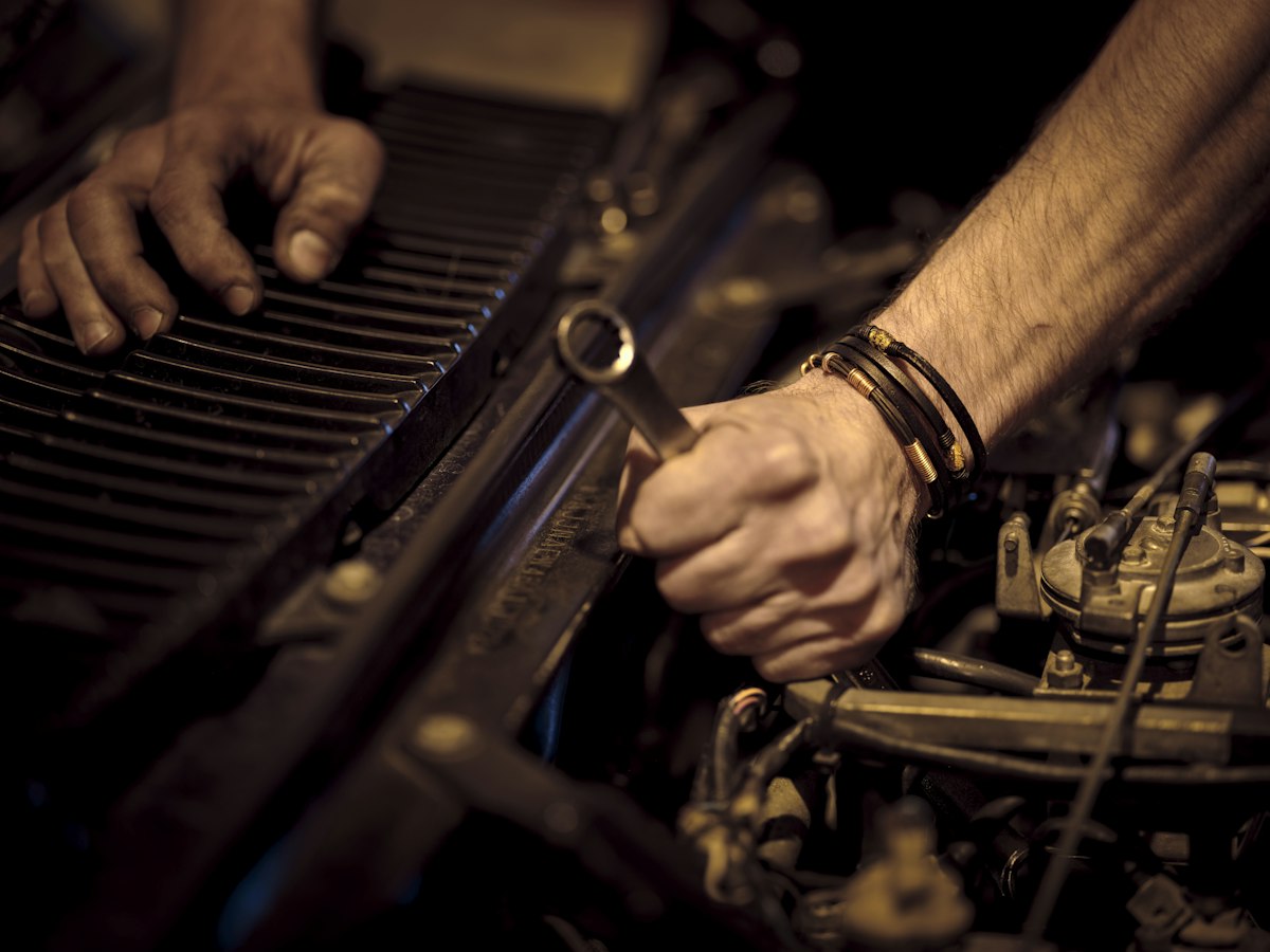 Mechanic hands tightening a bolt with a wrench