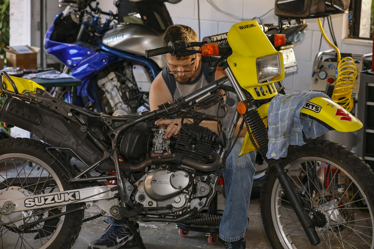 Mechanic inspecting a motorcycle frame and engine bay