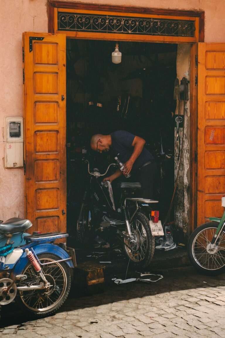 Mechanic working on a motorcycle at the workshop entrance