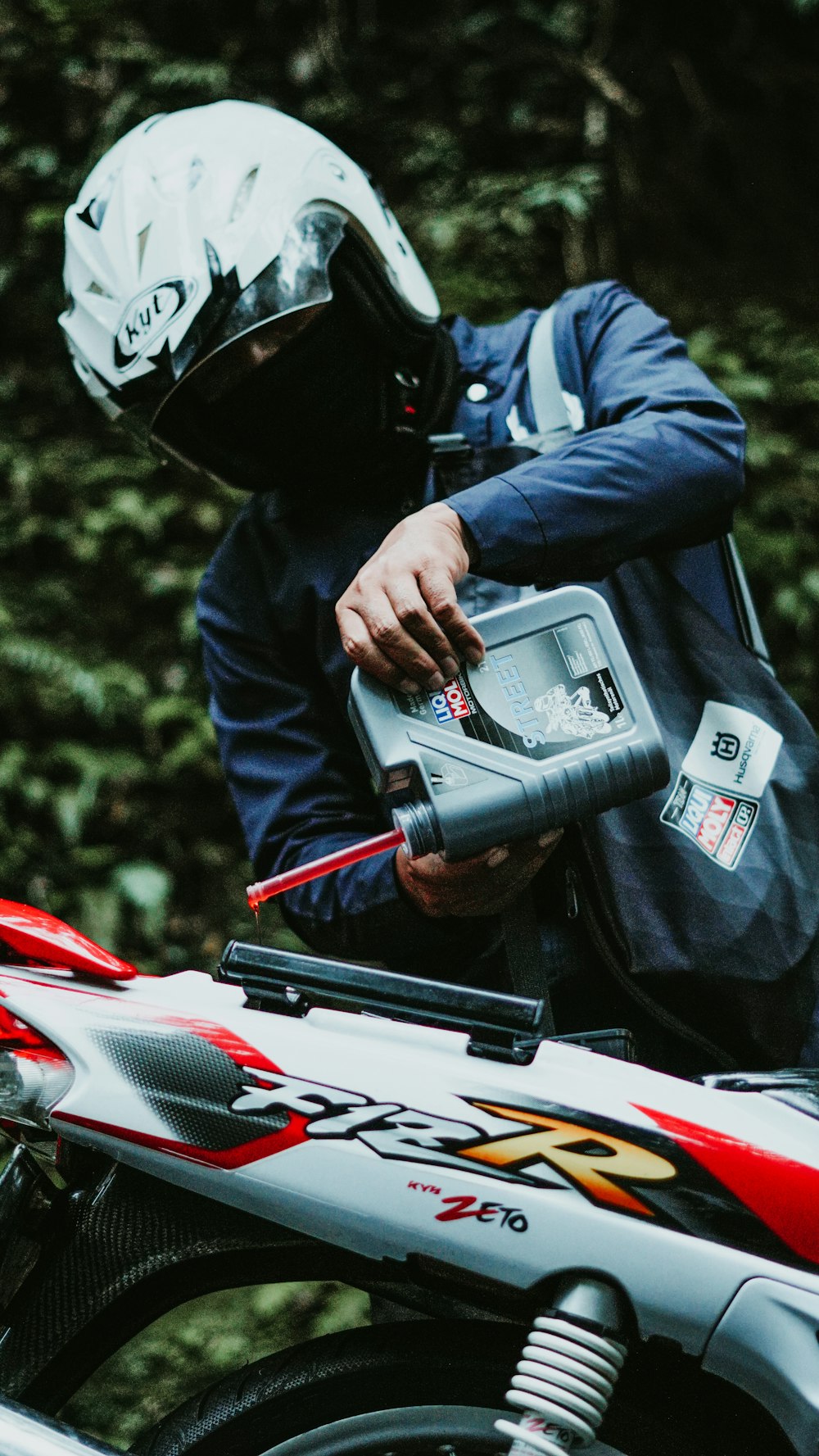 Rider pouring fresh engine oil into a motorcycle