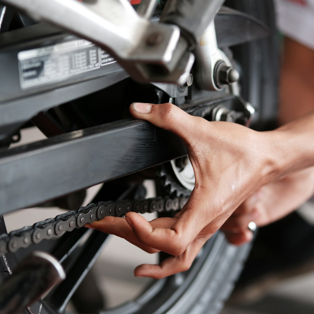 Hand checking a motorcycle tyre during inspection